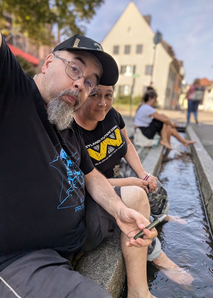 Il Teo e la Kry con i piedi in un canaletto di Friburgo in Brisgovia (Germania). Foto su "Nerd in Spalla: viaggiatori poco seri".